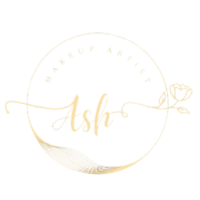Elegant gold circular logo for makeup artist "Ash," featuring decorative elements like a heart and leaf.